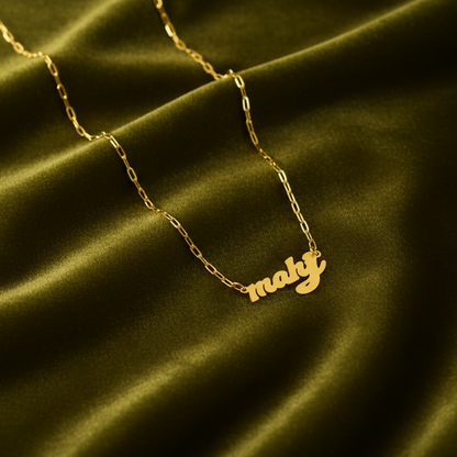 Gold necklace with 'mahj' as in mahjong pendant on a green satin background