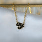 Product shot of gold oy necklace on white cloth.