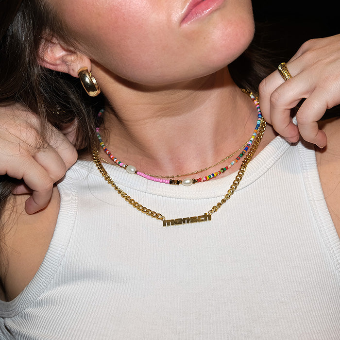 Layered necklaces worn by model in flash photo.